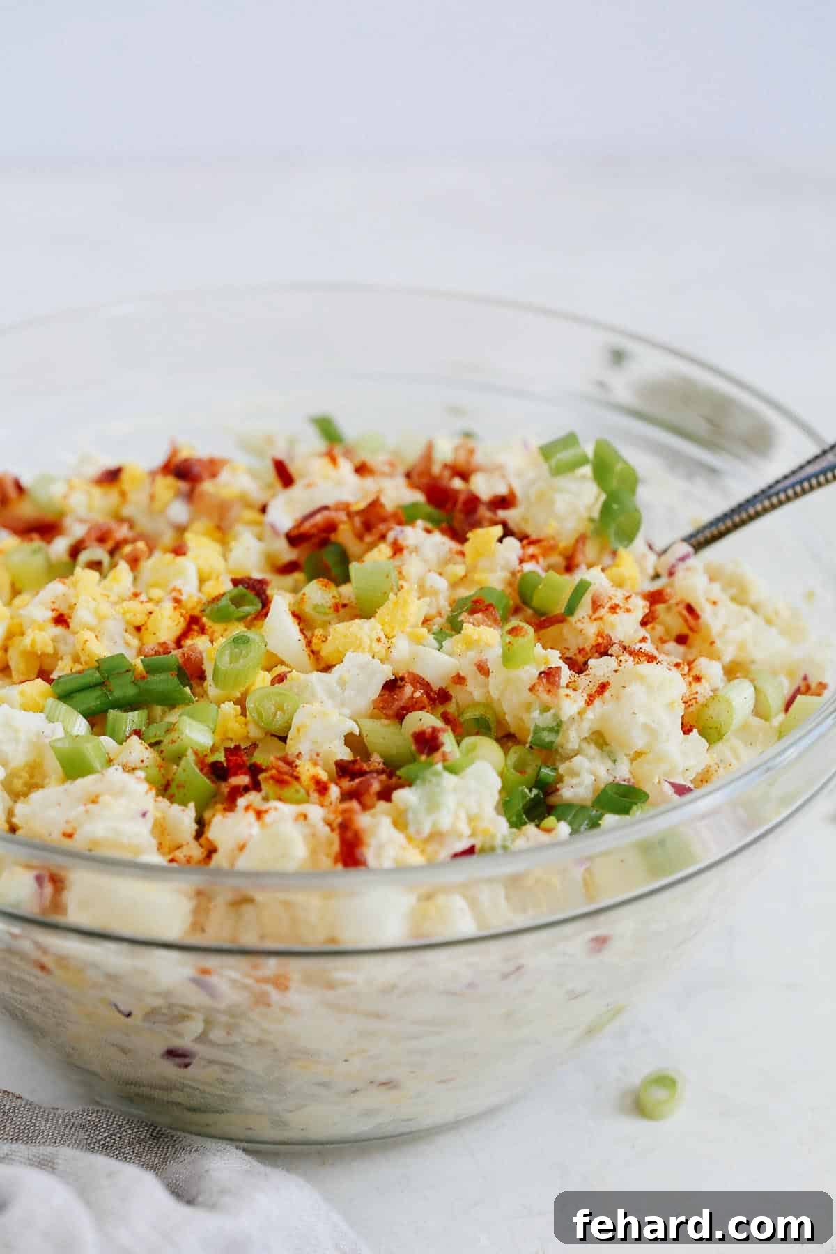 creamy potato salad in glass serving bowl