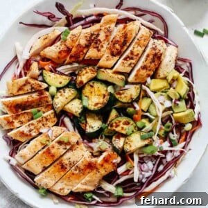Overhead shot of cabbage salad with grilled chicken, perfectly arranged in a bowl.