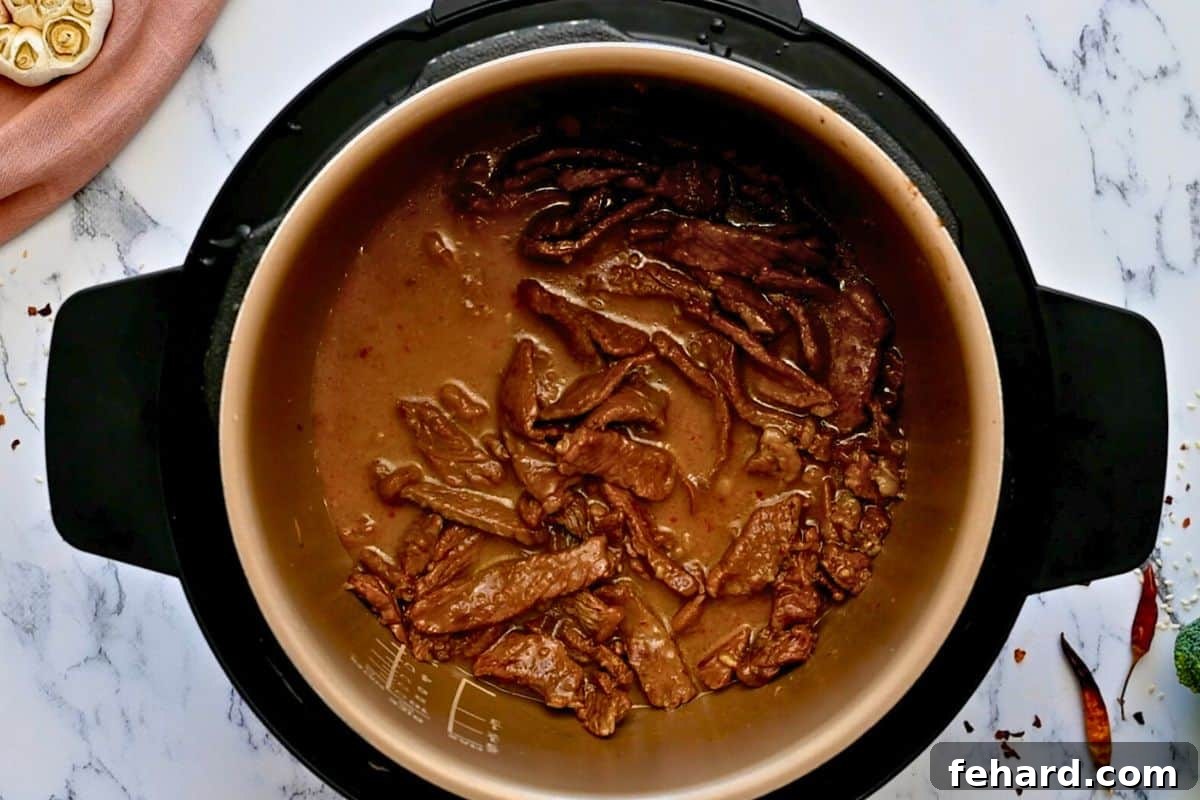 Instant Pot Beef and Broccoli Recipe The tender beef coated in a rich, glossy brown sauce inside the Instant Pot's inner pot, after the thickening step.