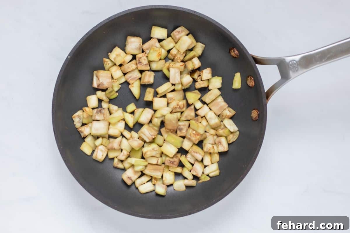 Cubed eggplant sauteed in a small frying pan until just golden and slightly caramelized.