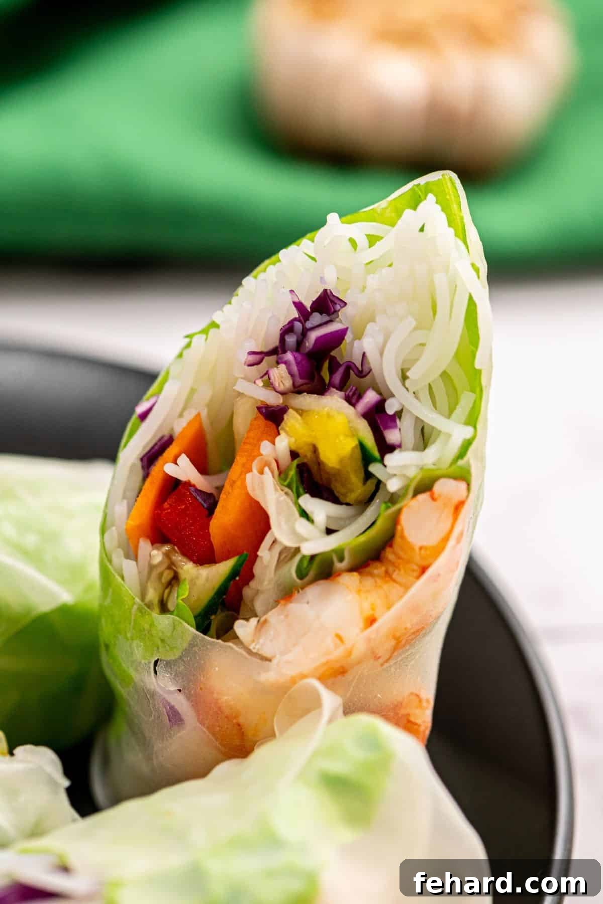 Homemade Fresh Spring Rolls with Peanut Sauce Spring Roll Cut Open showing shrimp, mangos, bell peppers, and cabbage. Highlighting fresh ingredients for a healthy meal.