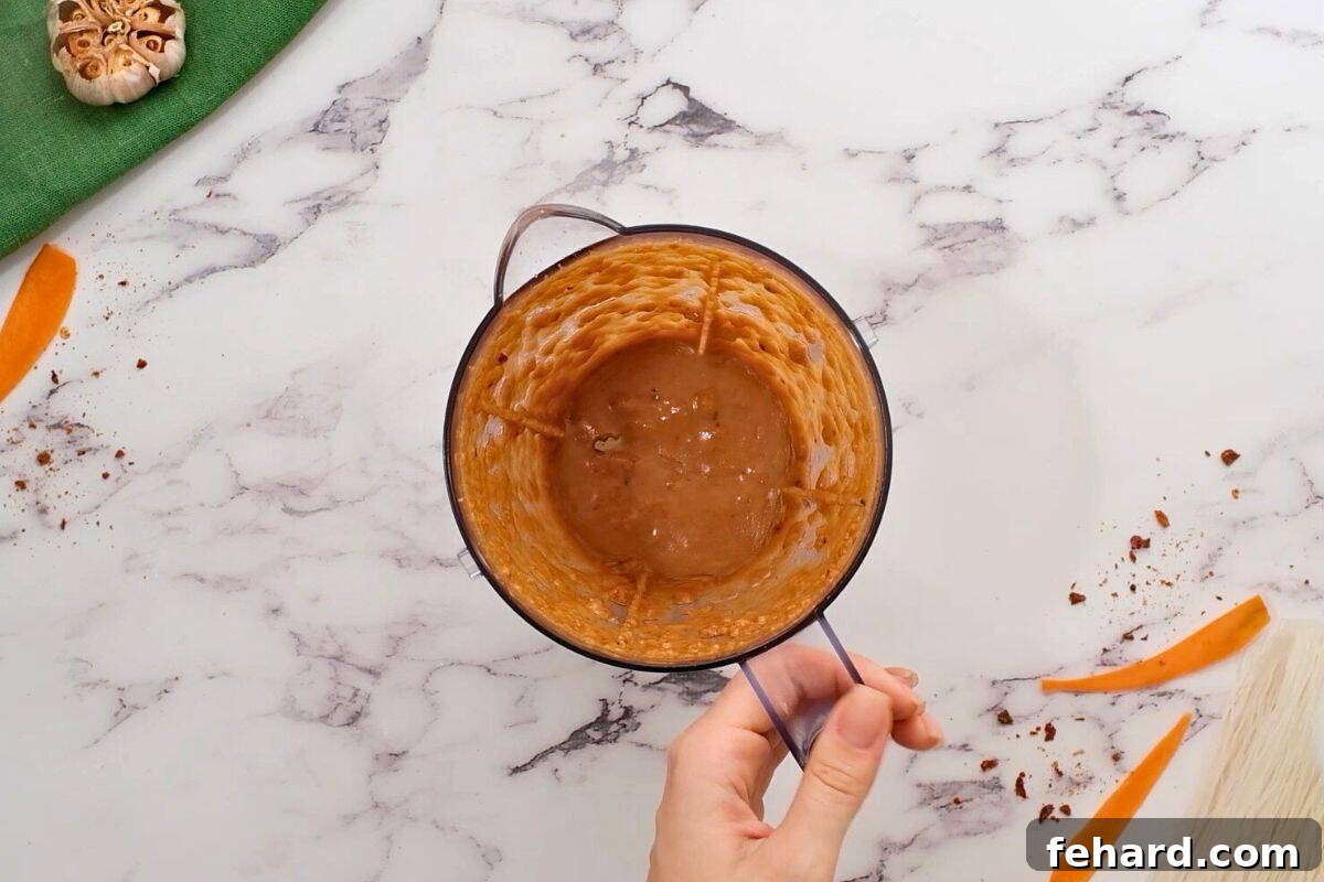 Creamy Peanut Dipping Sauce for Spring Rolls Peanut sauce blended together in small blender for dipping spring rolls, showing its creamy texture.