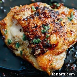 Close up of chicken thighs in butter sauce inside of a cast iron skillet