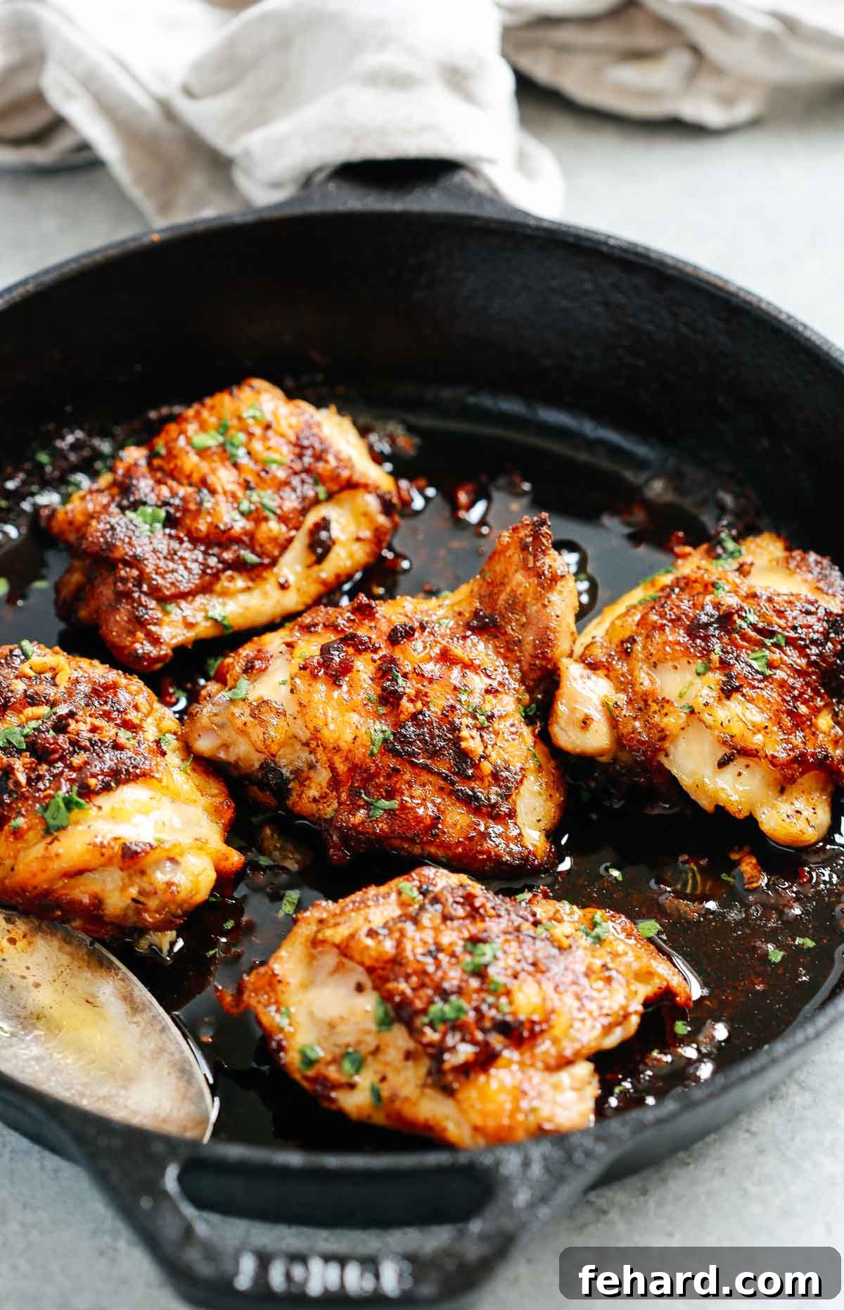 Close up of perfectly cooked, crispy chicken thighs in a cast iron skillet, ready to be served.