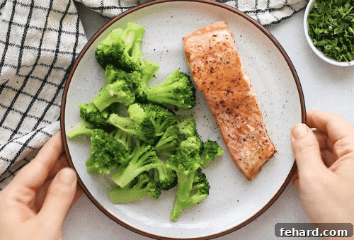 Plated pan-seared salmon with broccoli, garnished with lemon