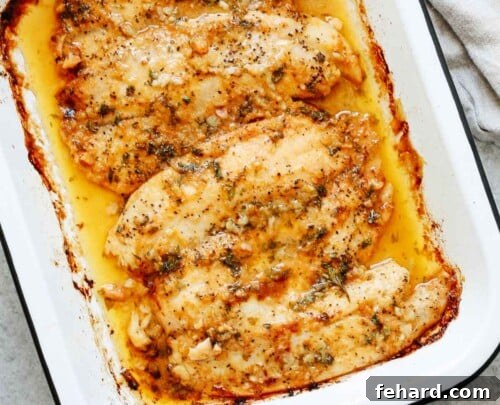 Overhead view of a baked tilapia on a baking sheet, ready to be served.