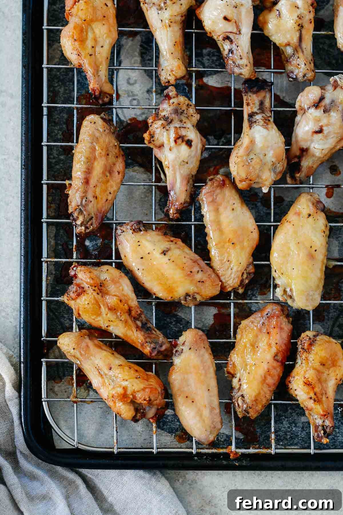 Salt and Pepper Chicken Wonders 3 Crispy oven-baked salt and pepper chicken wings resting on a wire rack over a baking sheet, allowing excess fat to drain.