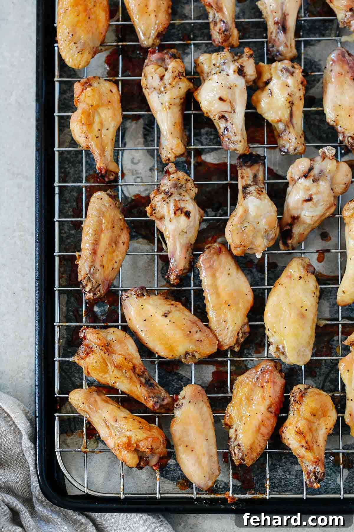 Salt and Pepper Chicken Wonders 4 Close-up view of perfectly seasoned, crispy salt and pepper chicken wings on a cooling rack, ready to be served.