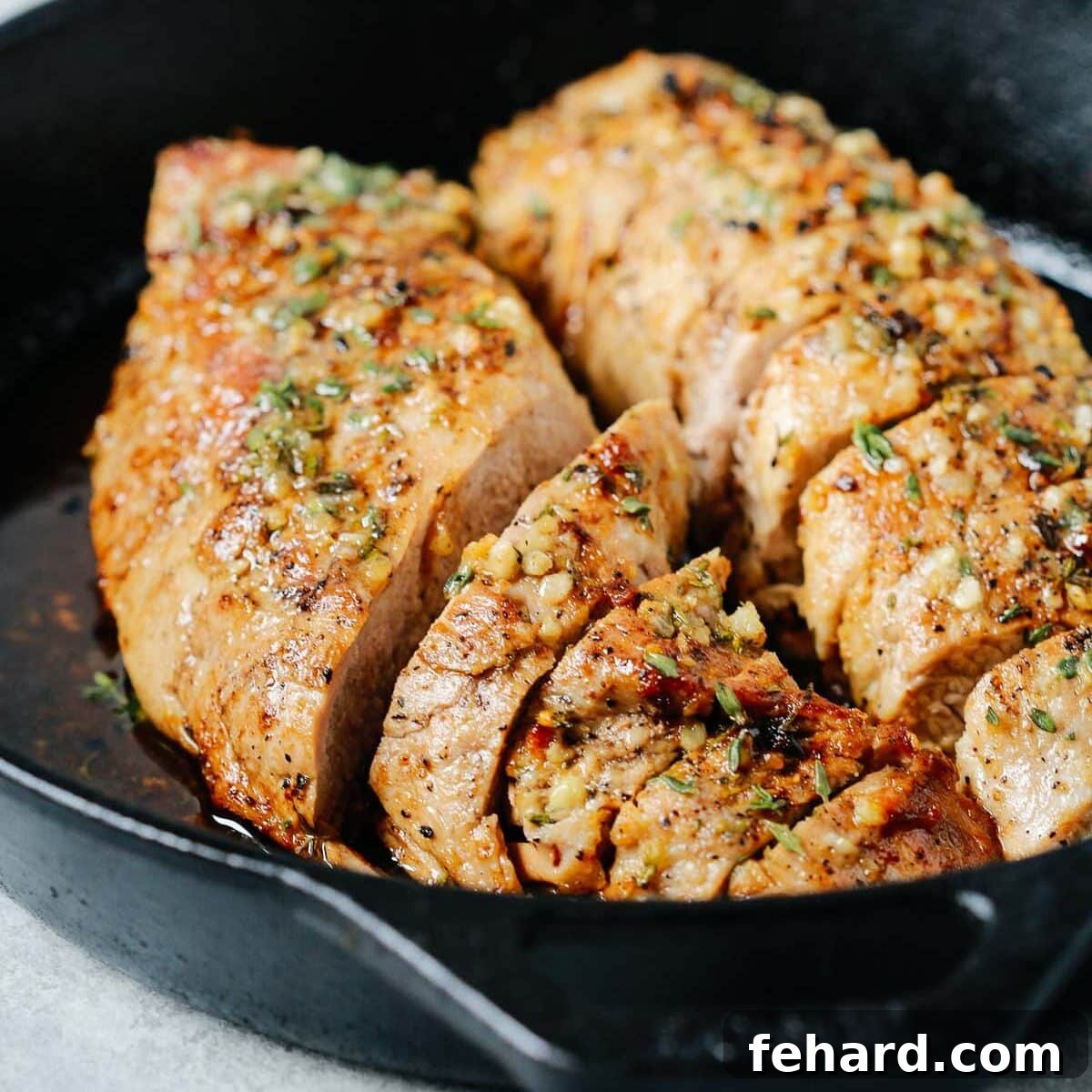 Mouthwatering Garlic Butter Pork Tenderloin 7 close up of cast iron skillet containing Pork Tenderloin