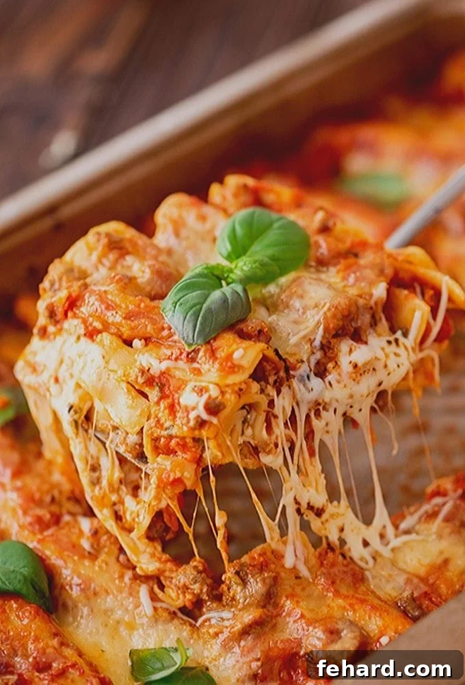 Easy Homemade Lasagna Being Pulled out of Pan, showcasing perfectly melted cheese and rich layers.