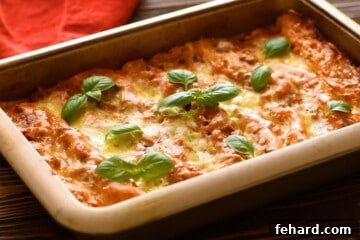 Baked Lasagna topped with fresh basil, steaming hot from the oven in a large baking dish.
