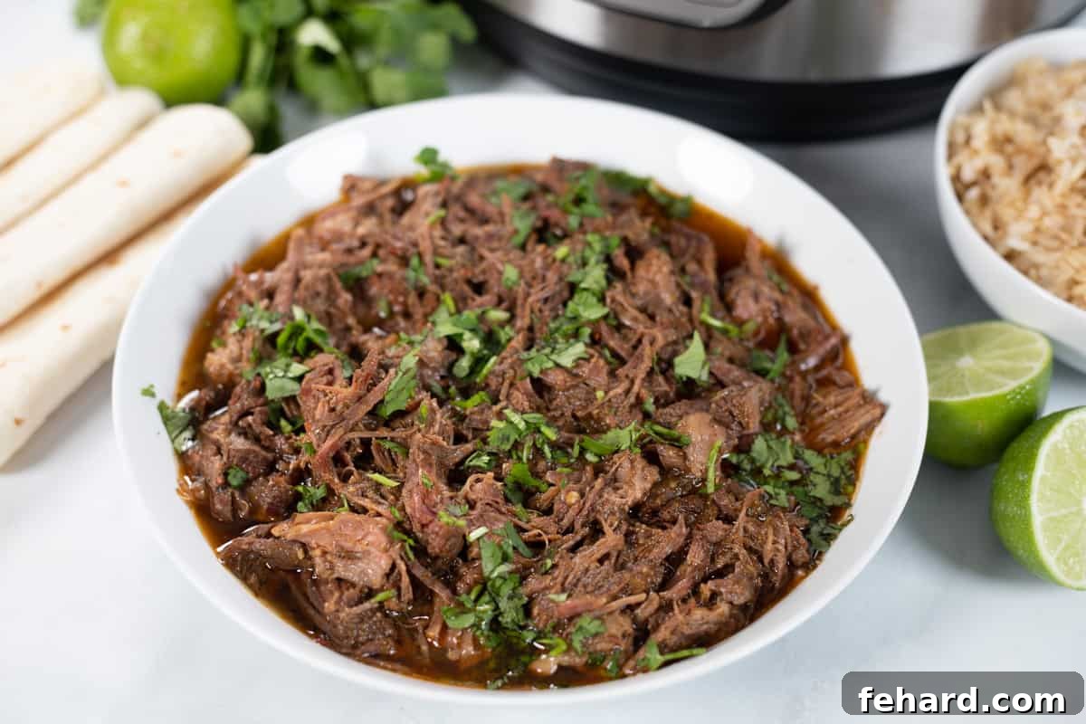 Copycat Barbacoa A generous portion of Beef Barbacoa in a white bowl, with an Instant Pot visible in the background.