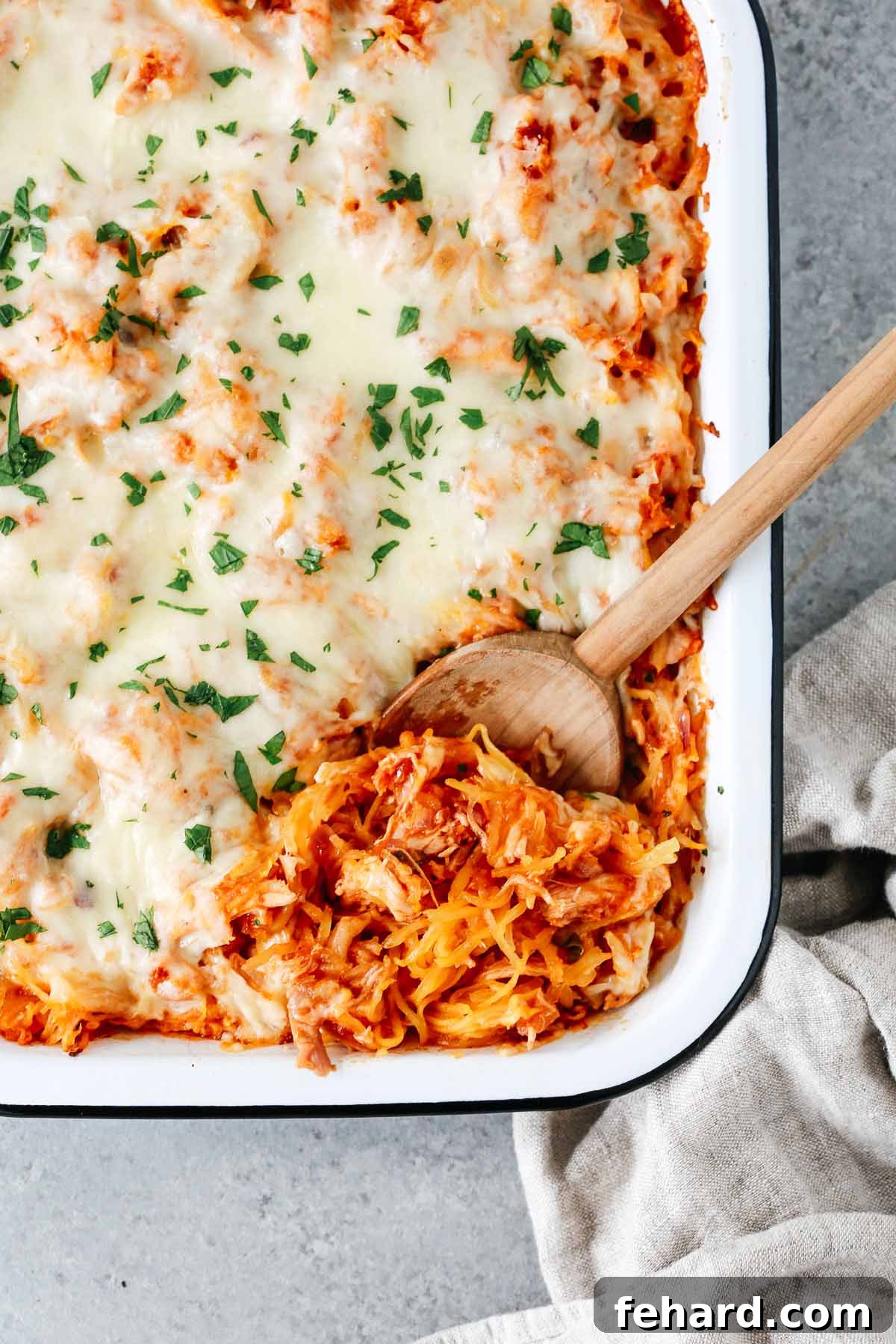 Overhead photo of a baking dish of spaghetti squash casserole with chicken and shredded cheese