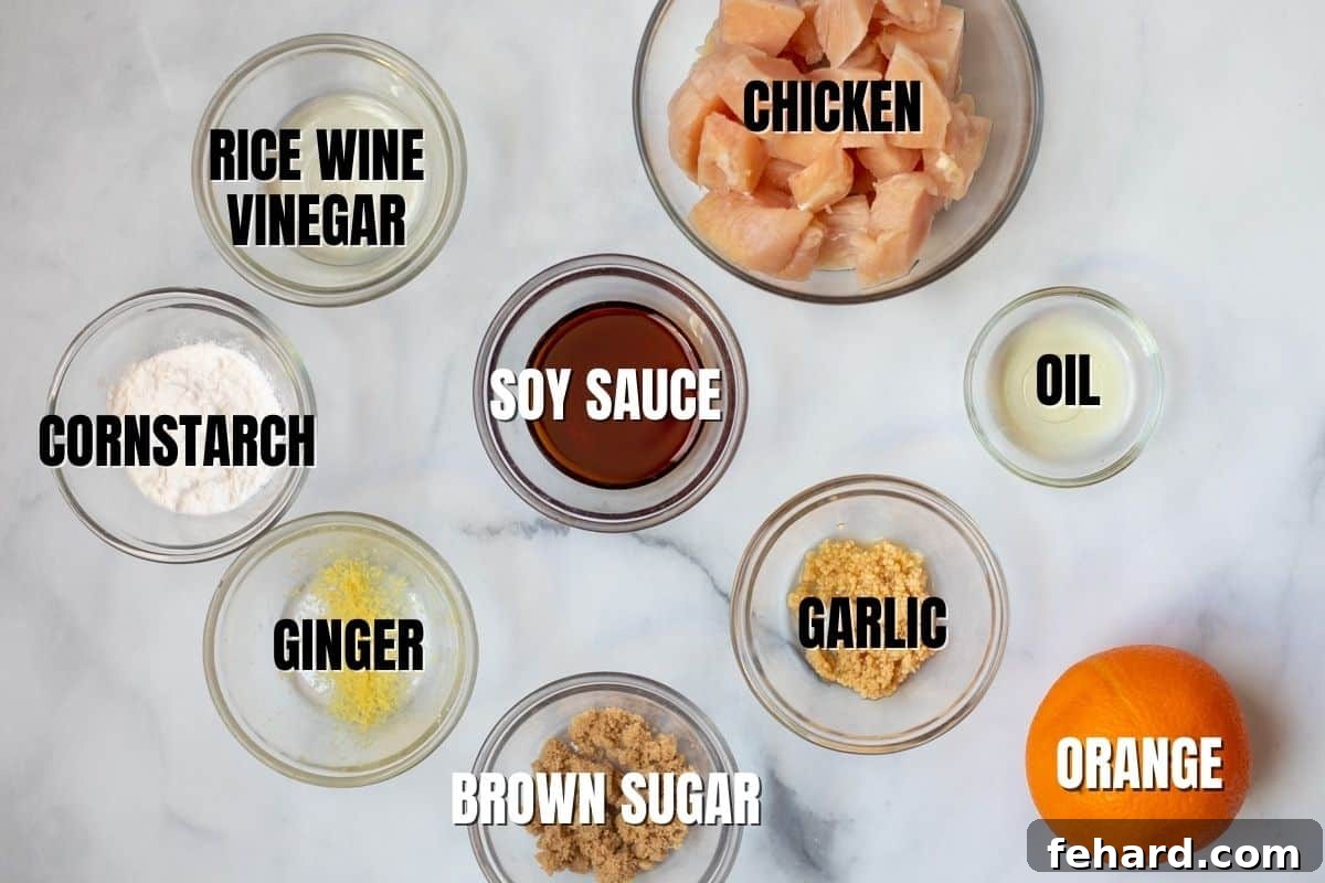 A vibrant flat lay of fresh, raw ingredients for homemade Orange Chicken, including diced chicken, fresh oranges, soy sauce, ginger, garlic, and vinegar, all neatly arranged and ready for cooking.