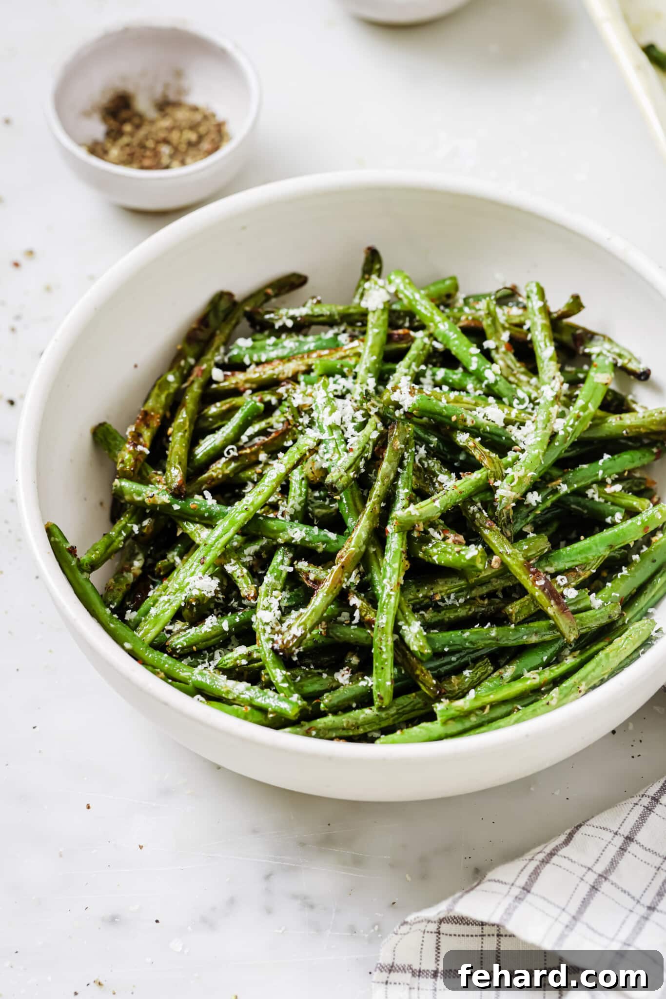 Garlic Parmesan Green Beans 2 Close up of a bowl of perfectly roasted parmesan green beans, garnished and ready to serve.