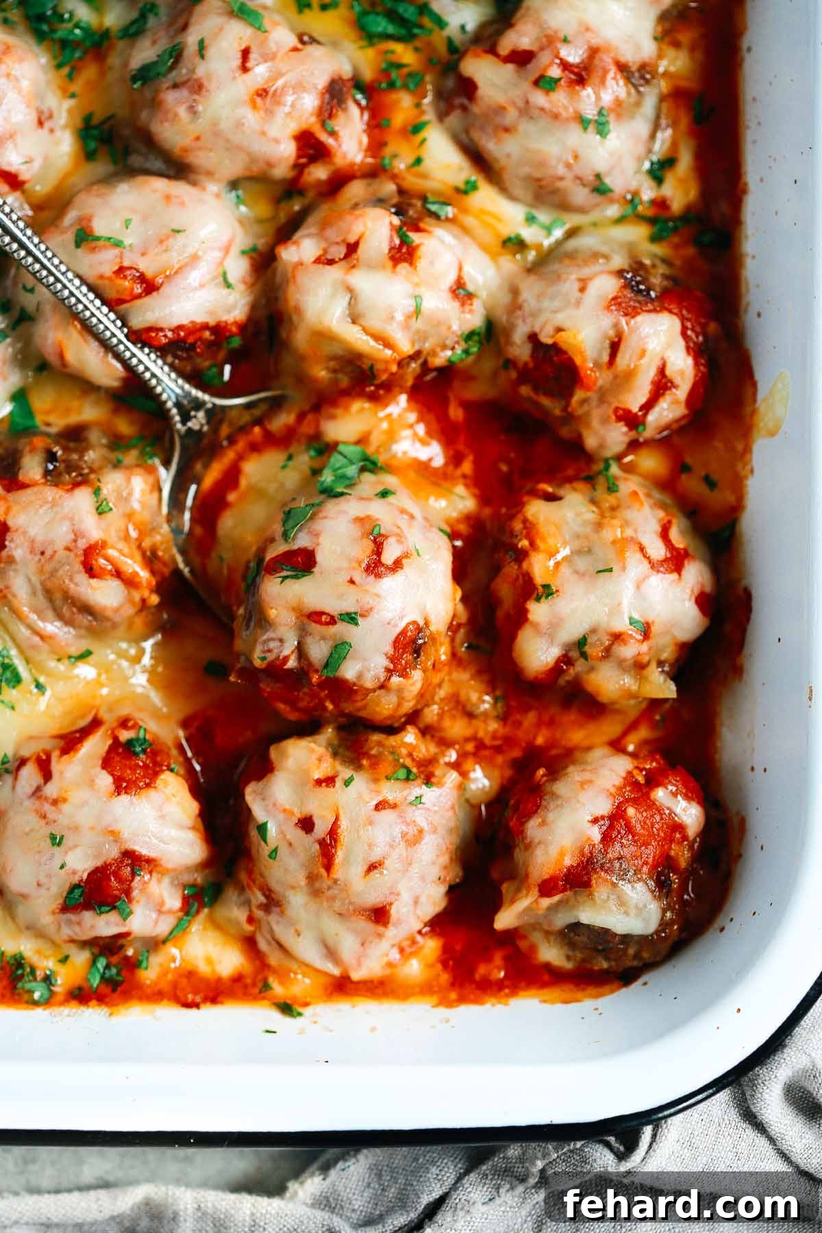 Comforting Meatball Bake 2 Close up of Baked Meatballs Casserole with a spoon lifting one meatball