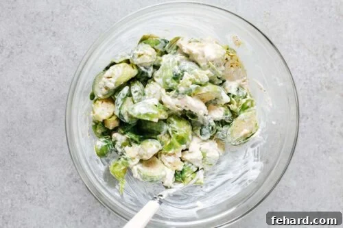 brussels sprouts with cheese mixture in a glass bowl.
