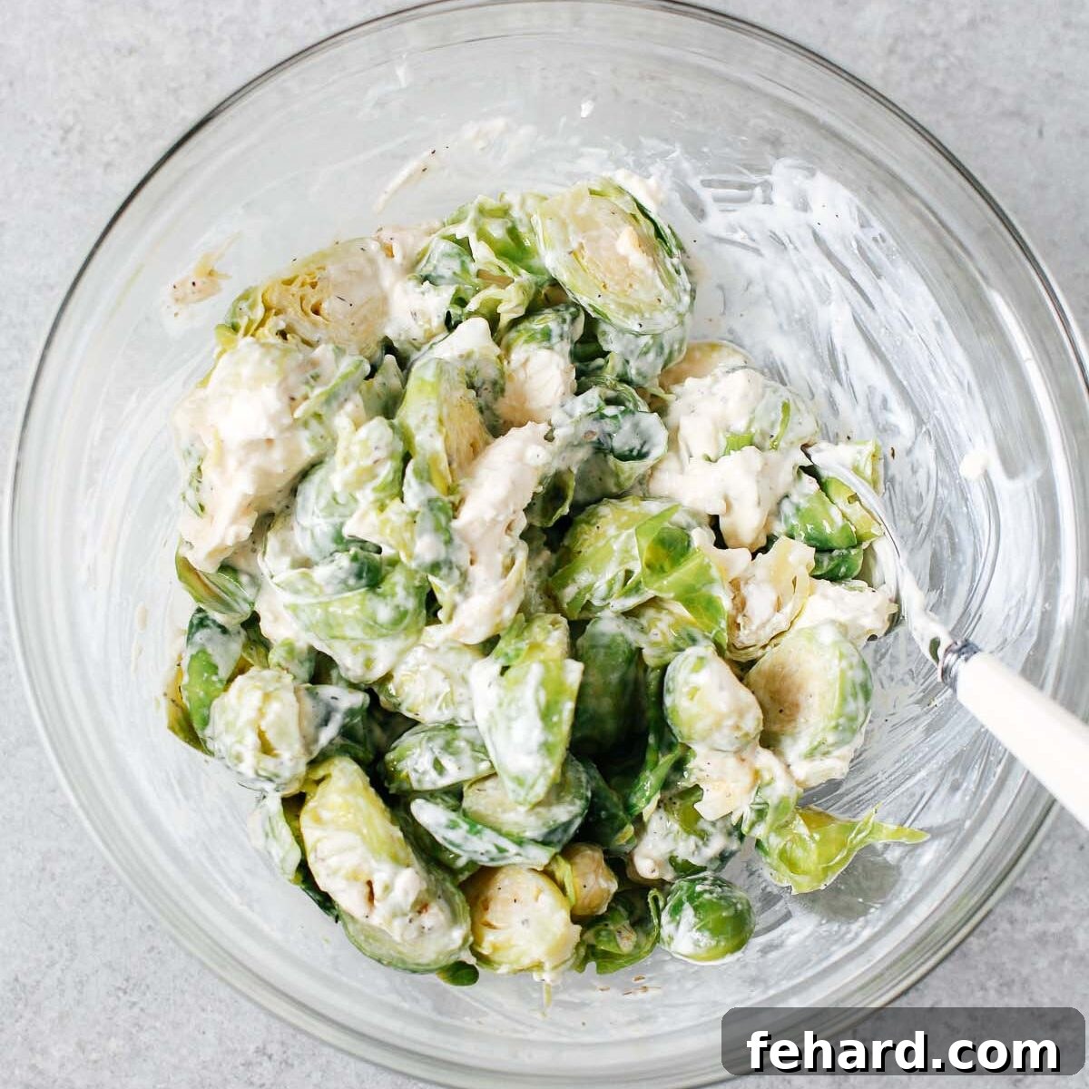 brussels sprouts with cheese mixture in a glass bowl.