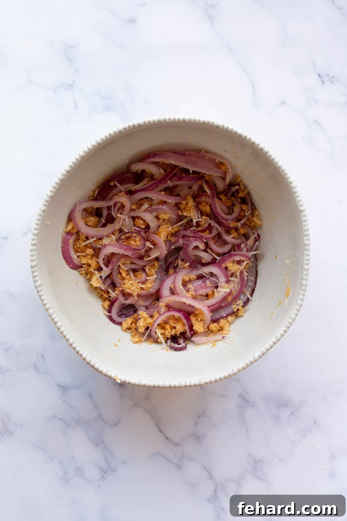 onions in a bowl with pork rinds, parmesan and salt and pepper.
