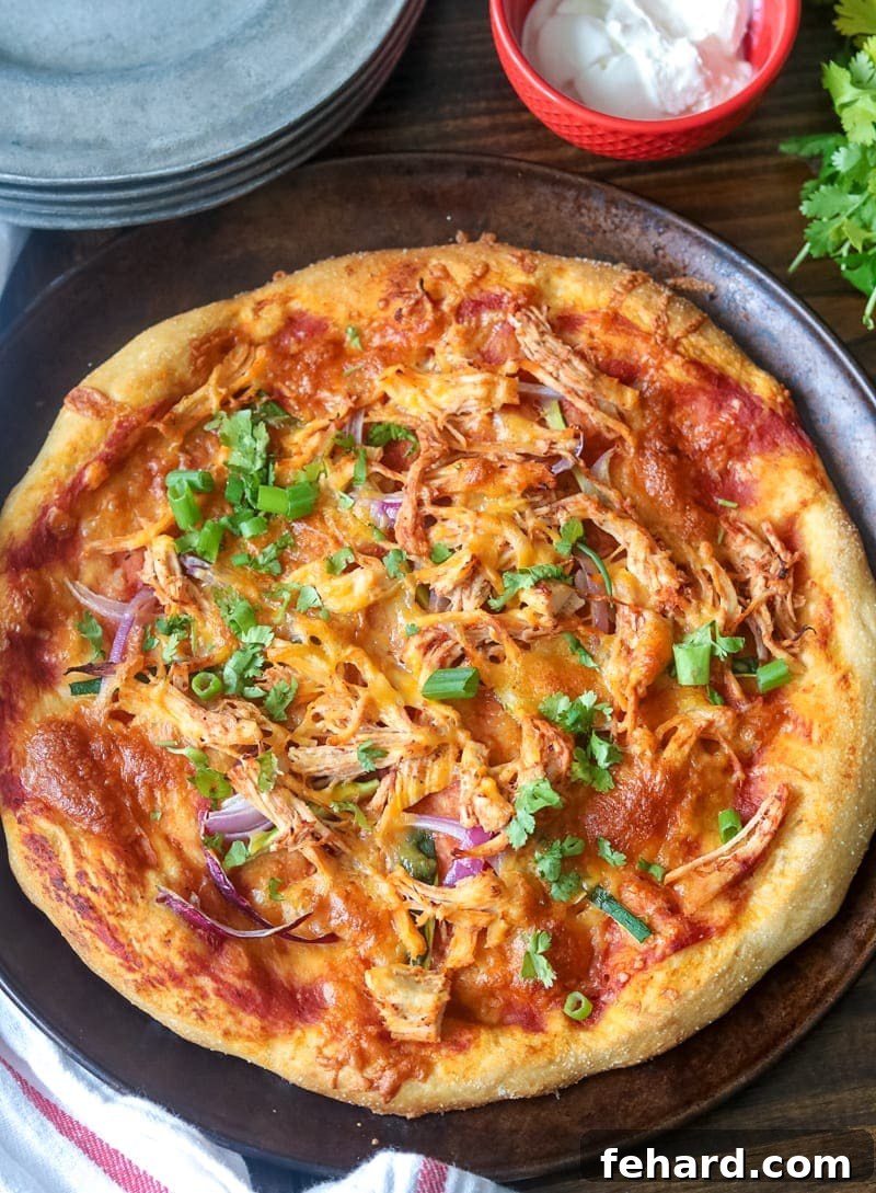 Delicious Chicken Fajita Pizza Rustic chicken fajita pizza on a wooden pan, surrounded by small silver dishes.