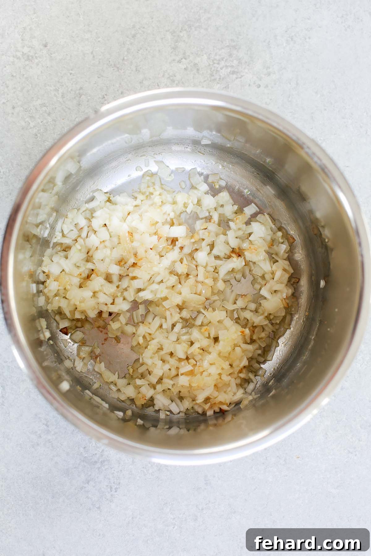 Chopped onions, garlic, and bell peppers being sautéed in the Instant Pot liner.