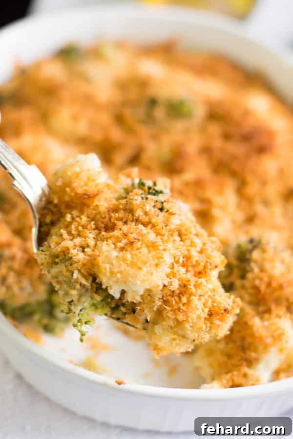 An inviting close-up of the delicious textures within the Cheesy Broccoli-Cauliflower Bake. A close-up shot of a spoonful of cheesy broccoli and cauliflower, highlighting the gooey melted cheese and tender vegetables.