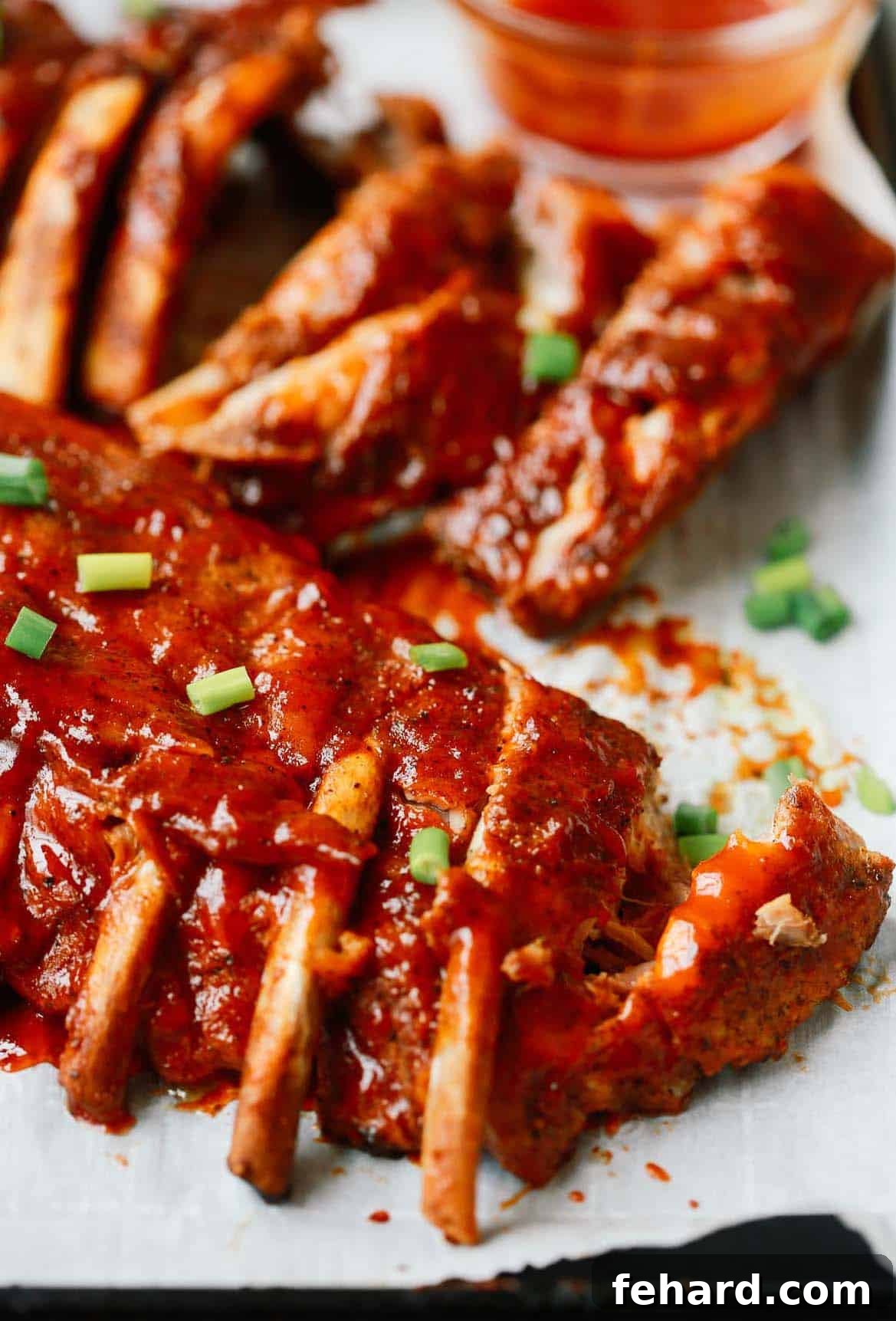 Effortlessly Tender Instant Pot Ribs 9 Close up photo of beautifully broiled Instant Pot baby back ribs, glistening with barbecue sauce.