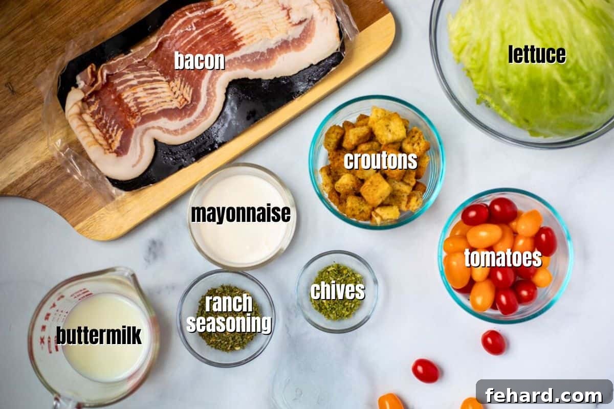 All the fresh ingredients for BLT salad and components for the creamy homemade salad dressing are neatly arranged and labeled on a kitchen counter.