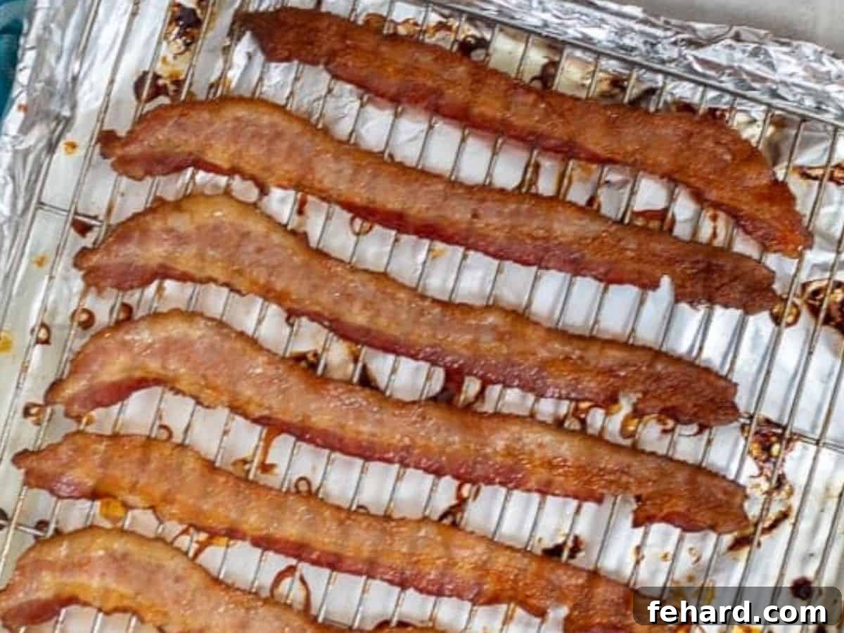Crispy bacon strips cooling on a wire rack over a baking sheet, ready to be crumbled for the BLT salad.