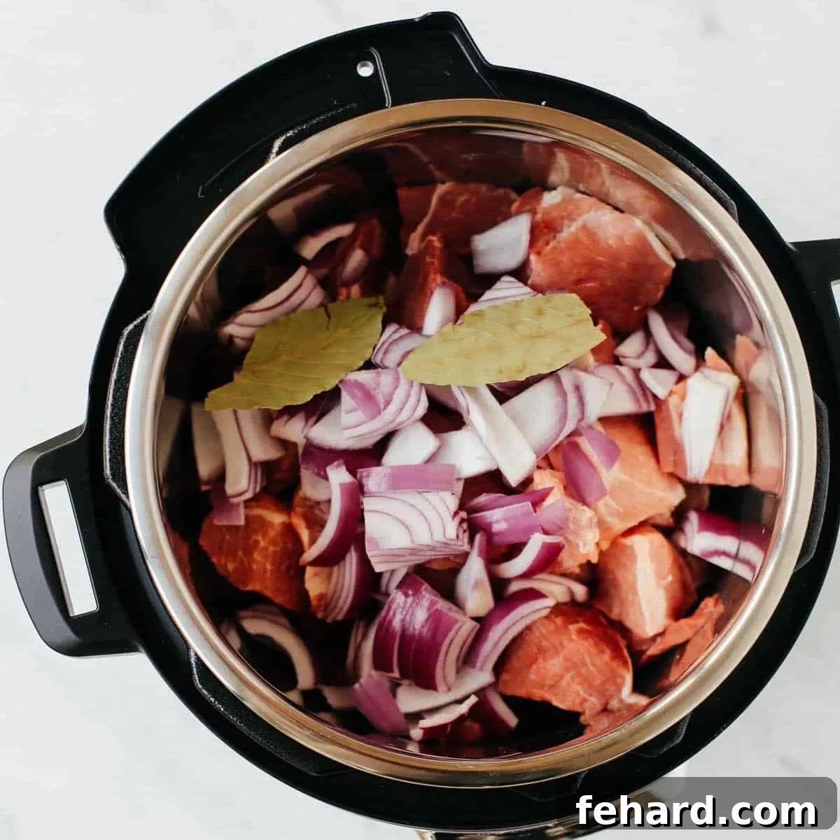 overhead view of instant pot containing pork shoulder bites 