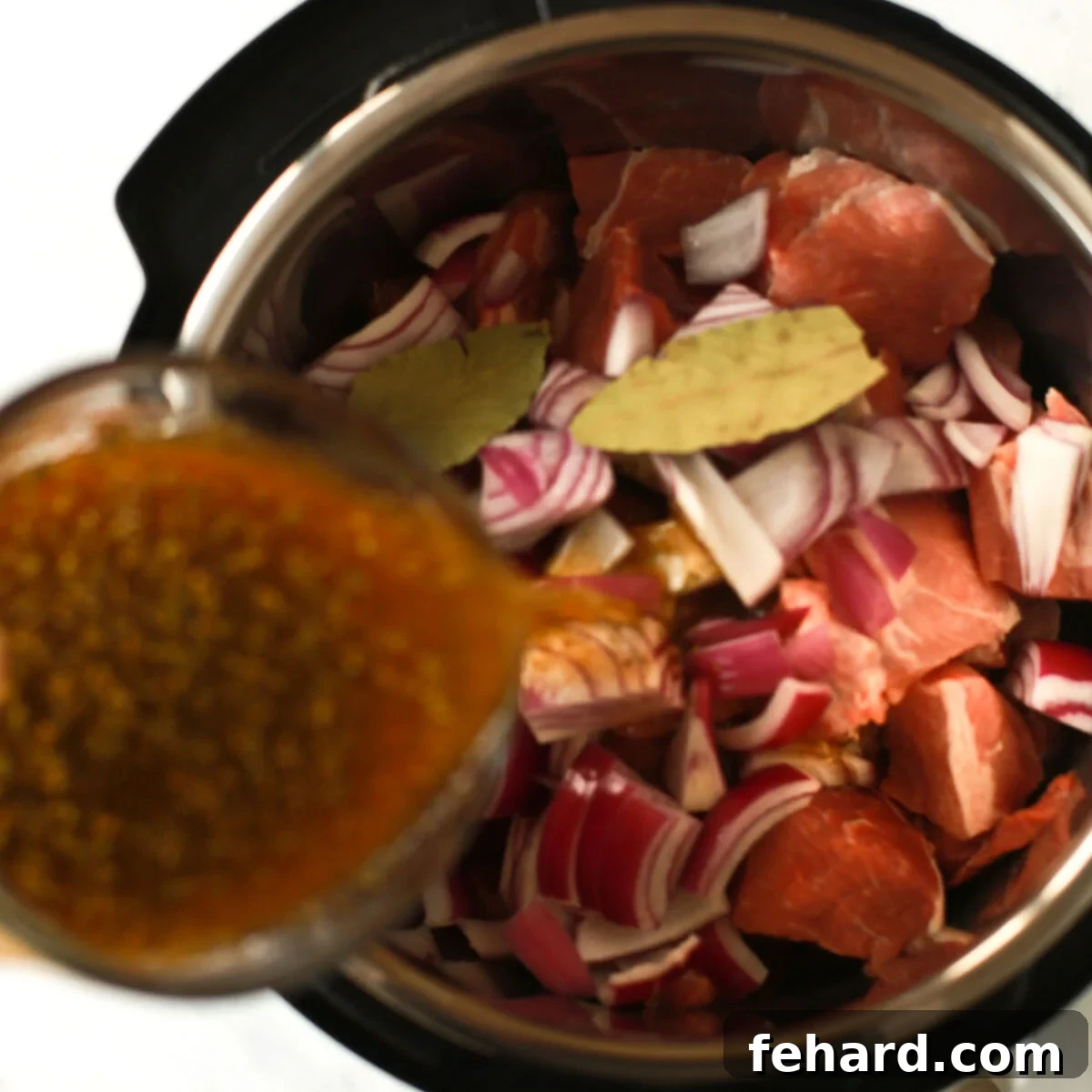 overhead view of beef broth being poured inside of an instant pot