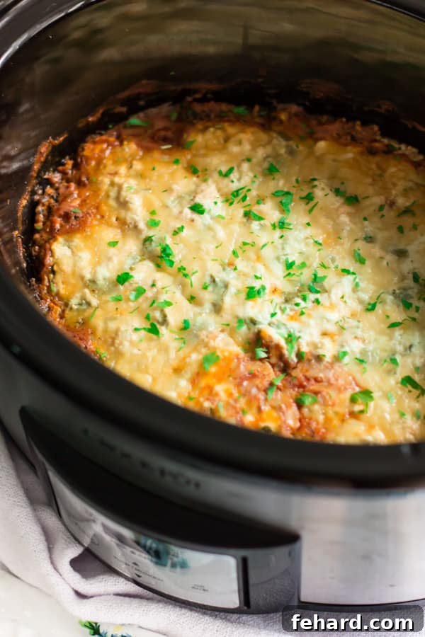 Slow Cooker Zucchini Lasagna - Ready to be enjoyed after a hands-off cooking process. Close up of perfectly cooked slow cooker zucchini lasagna, showing the melted cheese and tender layers.
