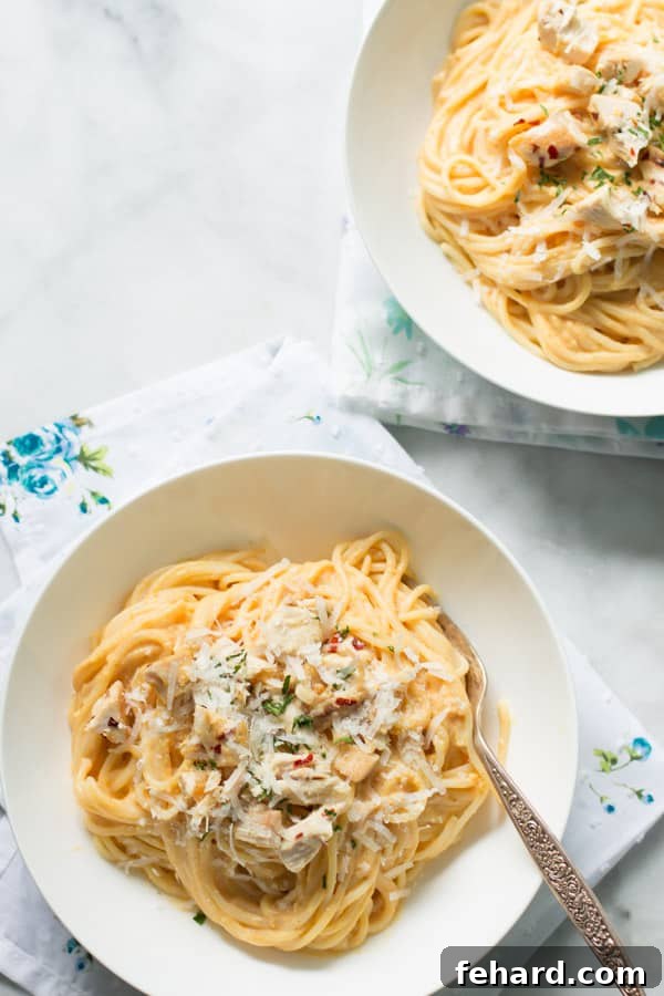 A vibrant bowl of pumpkin alfredo sauce pasta, creamy and inviting.