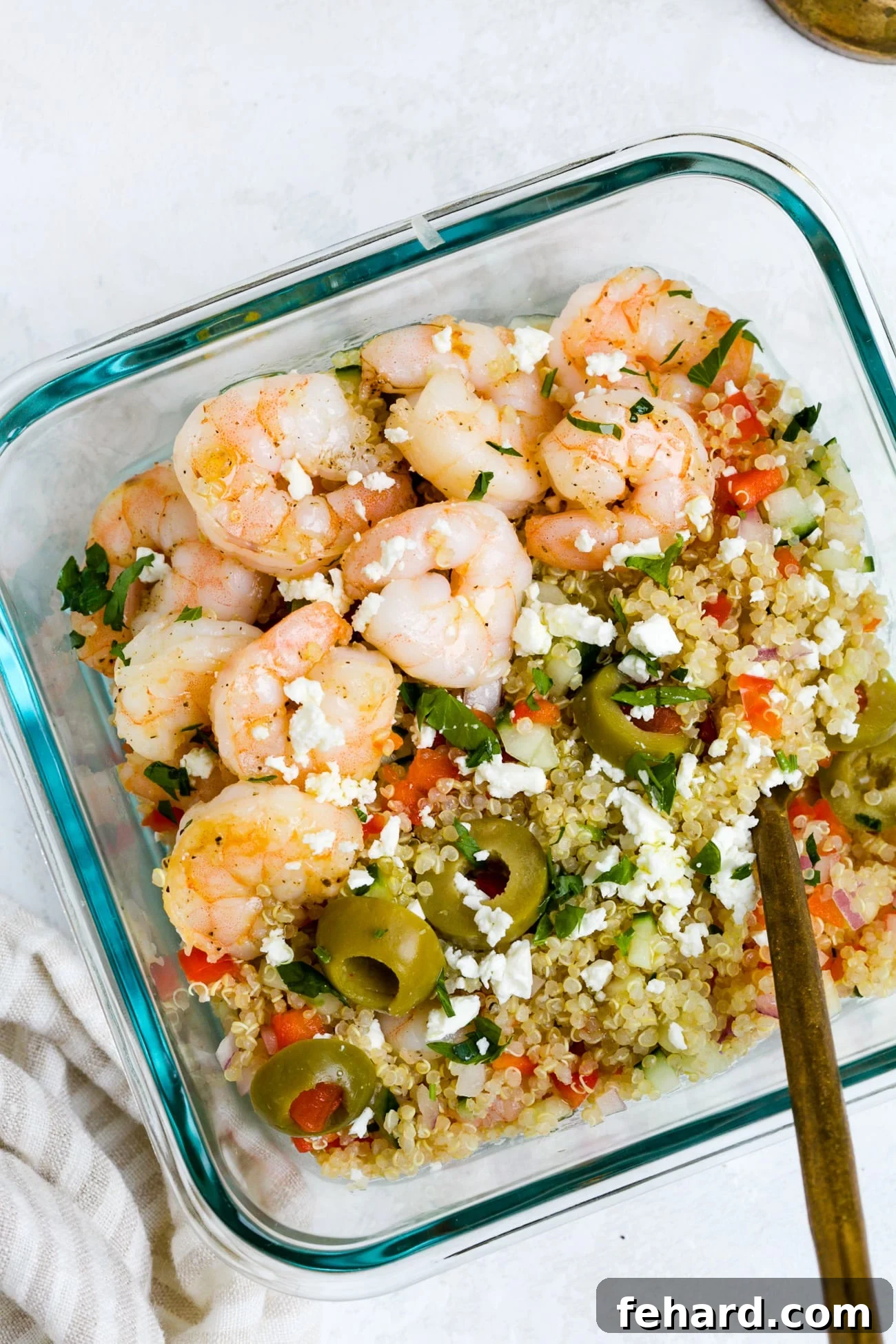 Vibrant Shrimp Quinoa Bowl 10 Overhead view of shrimp quinoa salad in a glass meal-prep bowl.