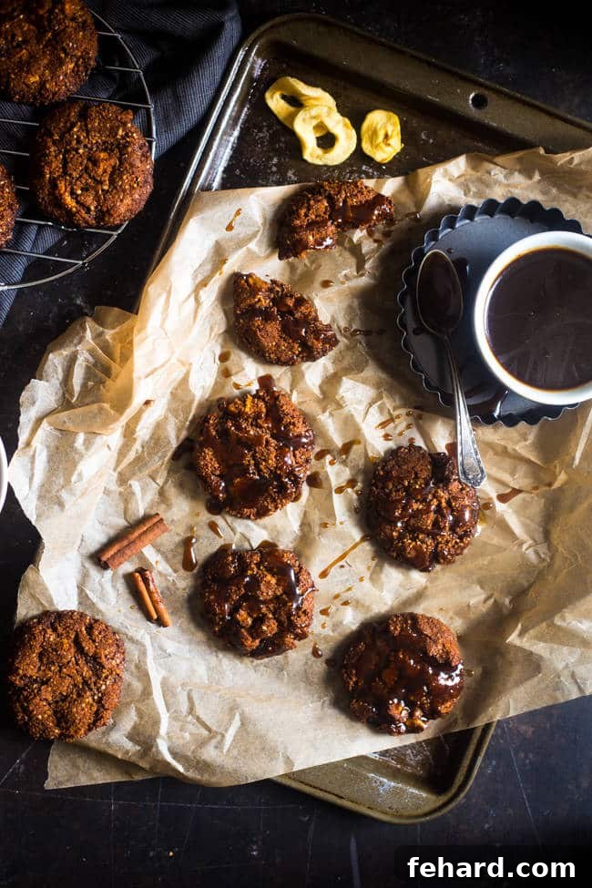 Healthy Ginger Snap cookies drizzled with caramel on parchment paper. These paleo ginger snaps offer a delightful blend of spice and sweetness.