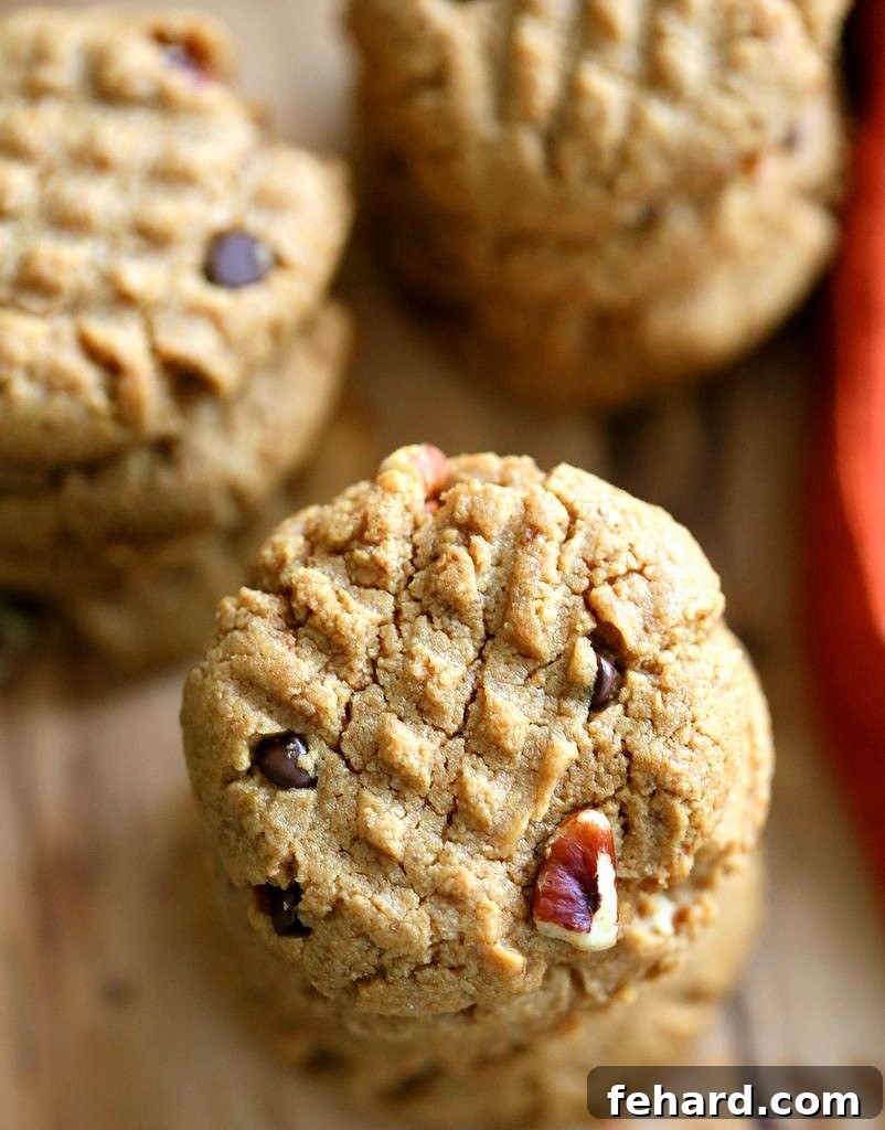 An overhead view of a stack of Vegan Peanut Butter Cookies With Pecans. These plant-based cookies are rich and nutty.