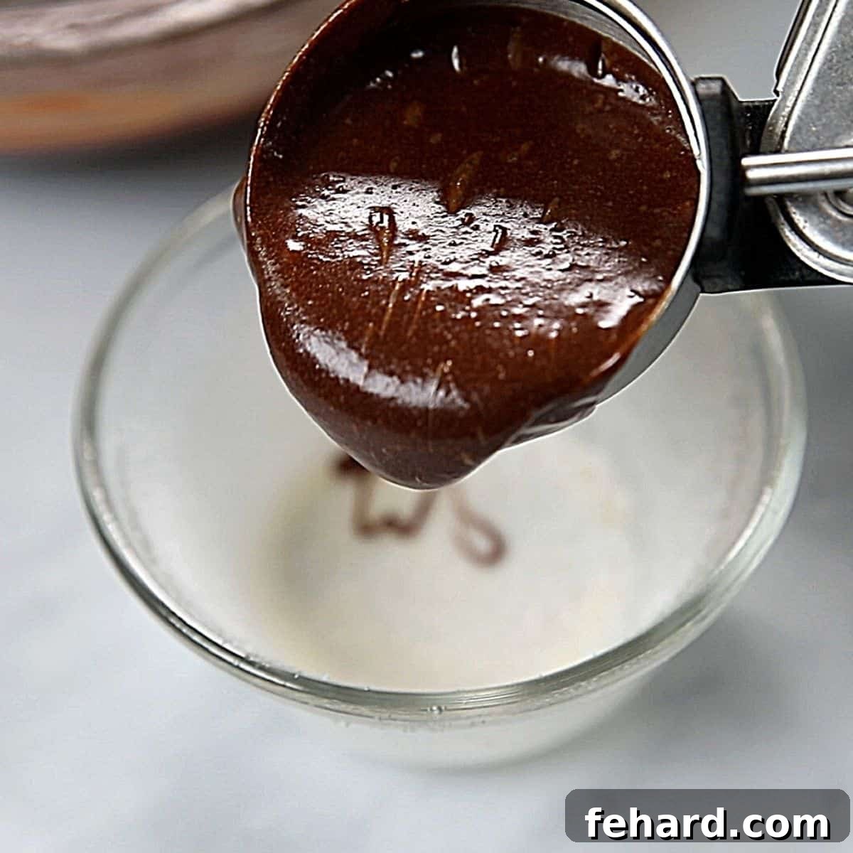 Molten Lava Cake Recipe An ice scream scooping chocolate batter into ramekins.