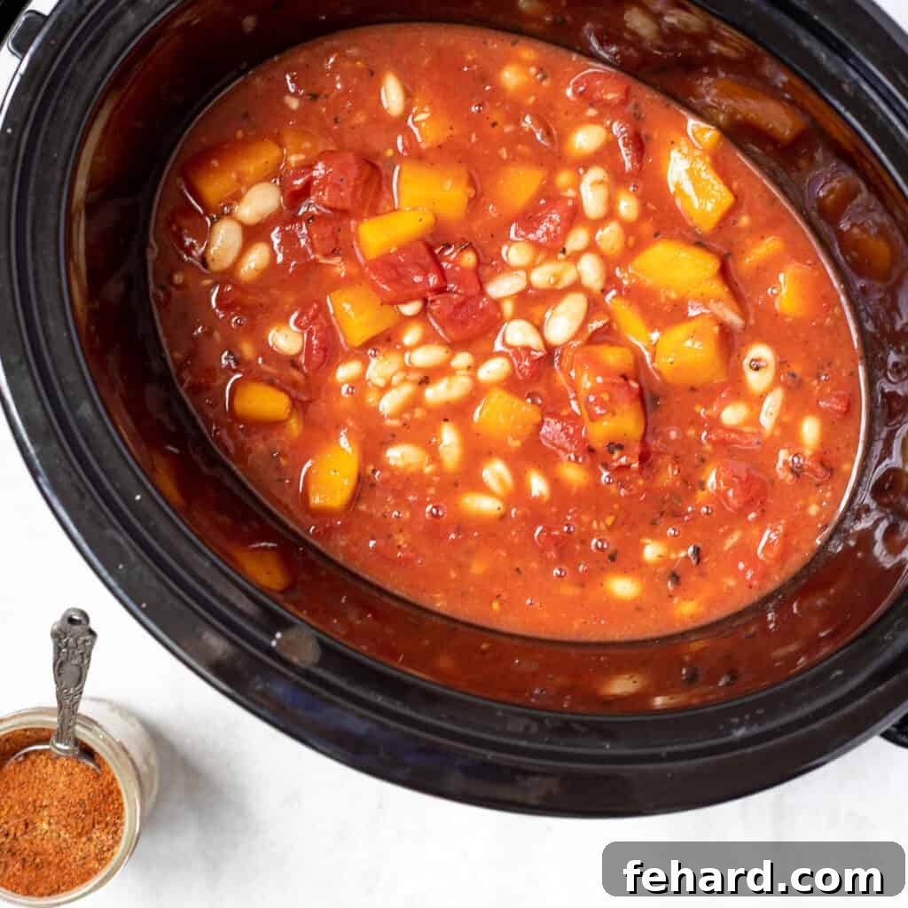 Butternut Squash Chili gently simmering in a slow cooker, emitting a comforting aroma.
