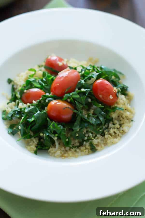 A delectable warm collard quinoa salad served in a elegant white bowl, garnished with fresh herbs, ready to be enjoyed.