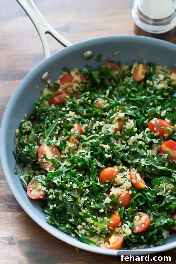 The warm collard quinoa salad simmering gently in a large skillet, showing the beautiful mix of ingredients before serving.