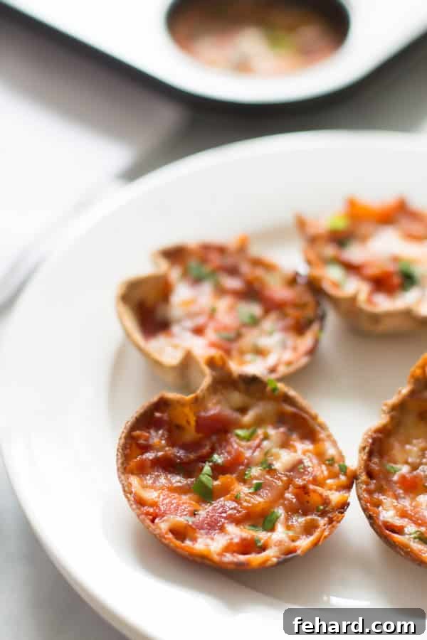 A hand holding a mini tortilla pizza, ready to be eaten, showing the perfect bite-sized portion.