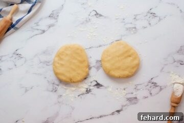 Two disks of homemade pie crust on floured work surface.