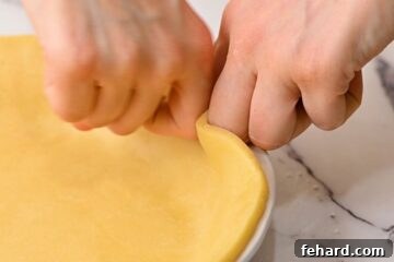 Two Hands showing how to flute a pie crust.