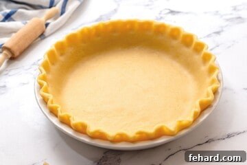 Pie Crust with fluted edges in white ceramic pie dish.
