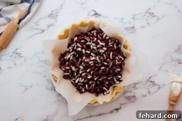 Pie crust lined with parchment paper and dried beans.