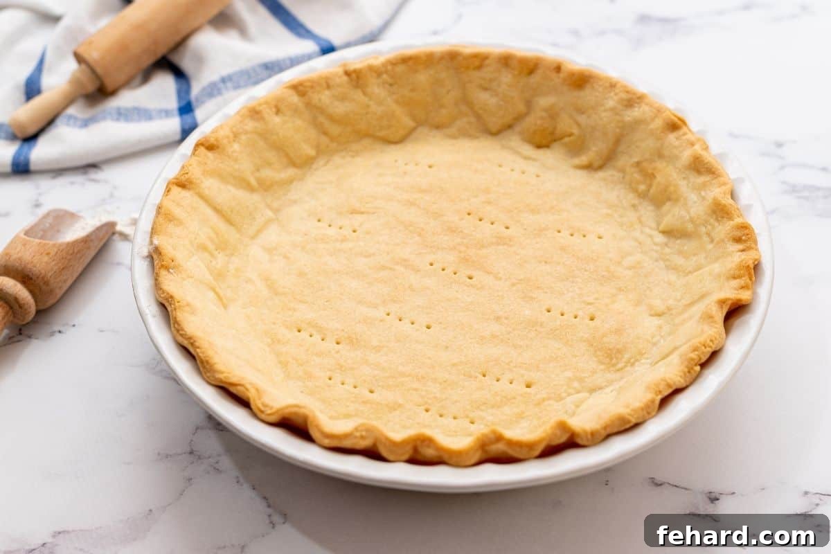 A perfectly partially baked, golden-brown pie crust, showcasing a crisp and set base ideal for various pie fillings.