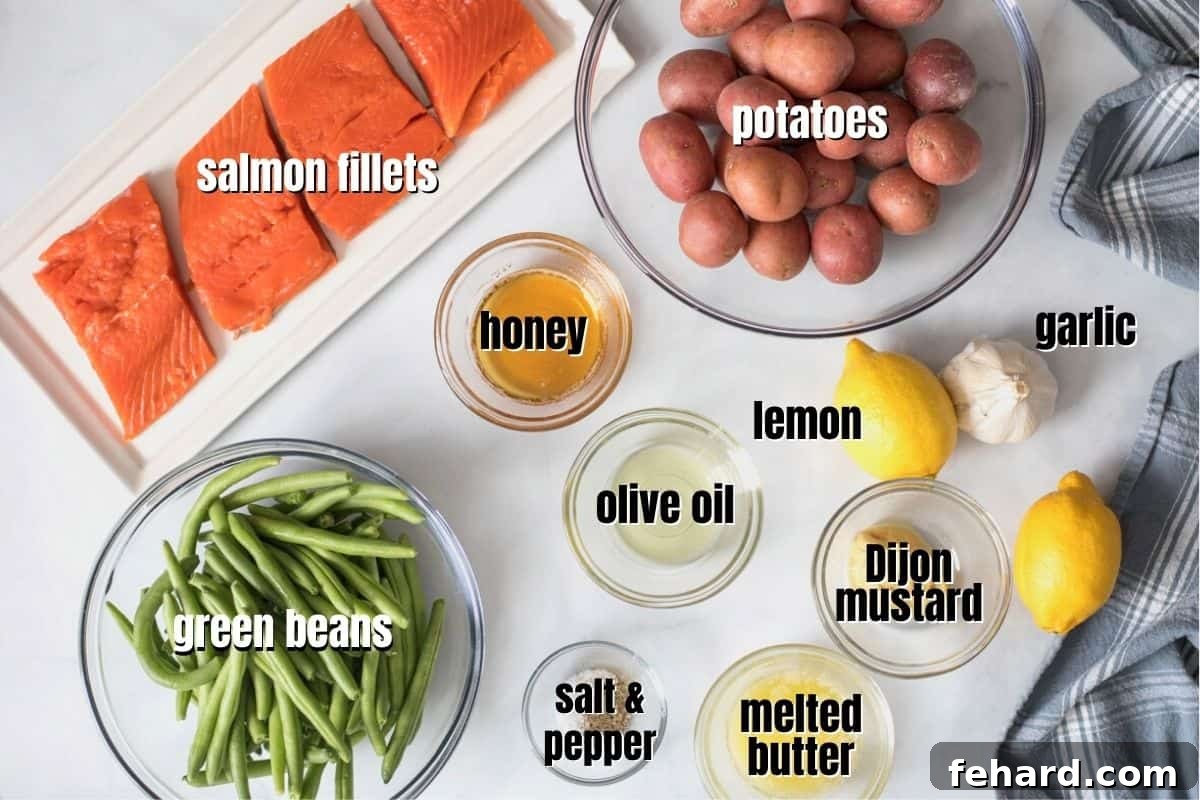 Easy Salmon Recipe Labeled ingredients for a Sheet Pan Salmon meal, including salmon fillets, petite red potatoes, fresh green beans, olive oil, garlic, honey, lemon, Dijon mustard, butter, salt, and pepper.