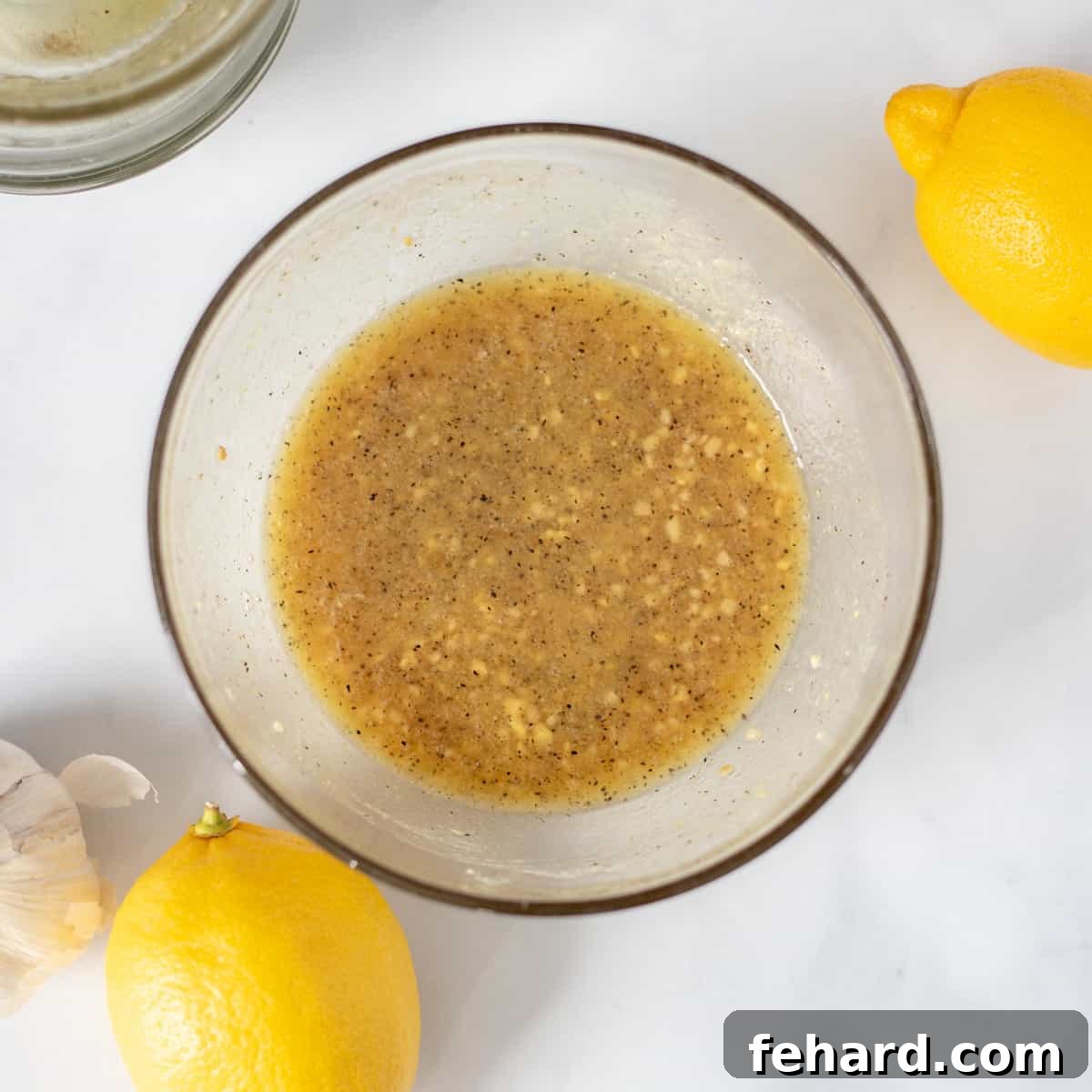 Honey Garlic Salmon Recipe A small mixing bowl contains a vibrant honey garlic lemon marinade, perfectly blended and ready for the salmon.