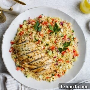 Chicken couscous salad in a large, white serving bowl.