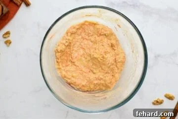 Batter for carrot cake mixed together in large mixing bowl.